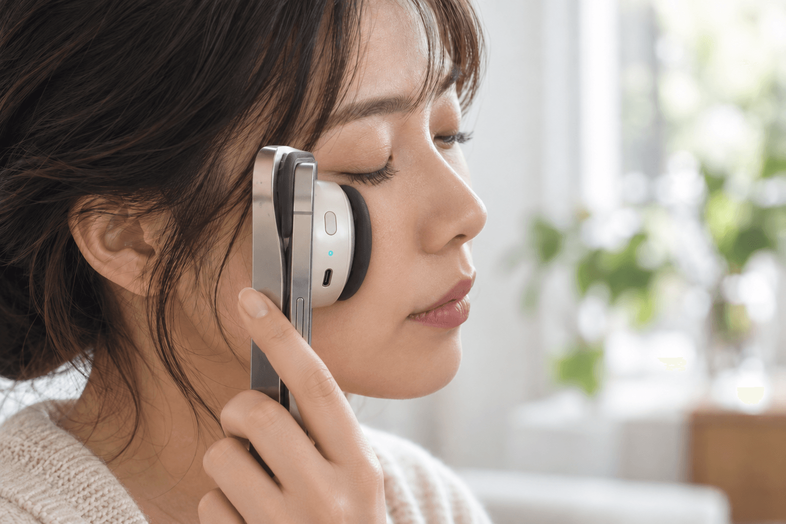 スマートフォン装着型肌撮影デバイスを頬へ軽く当てる使用イメージ
